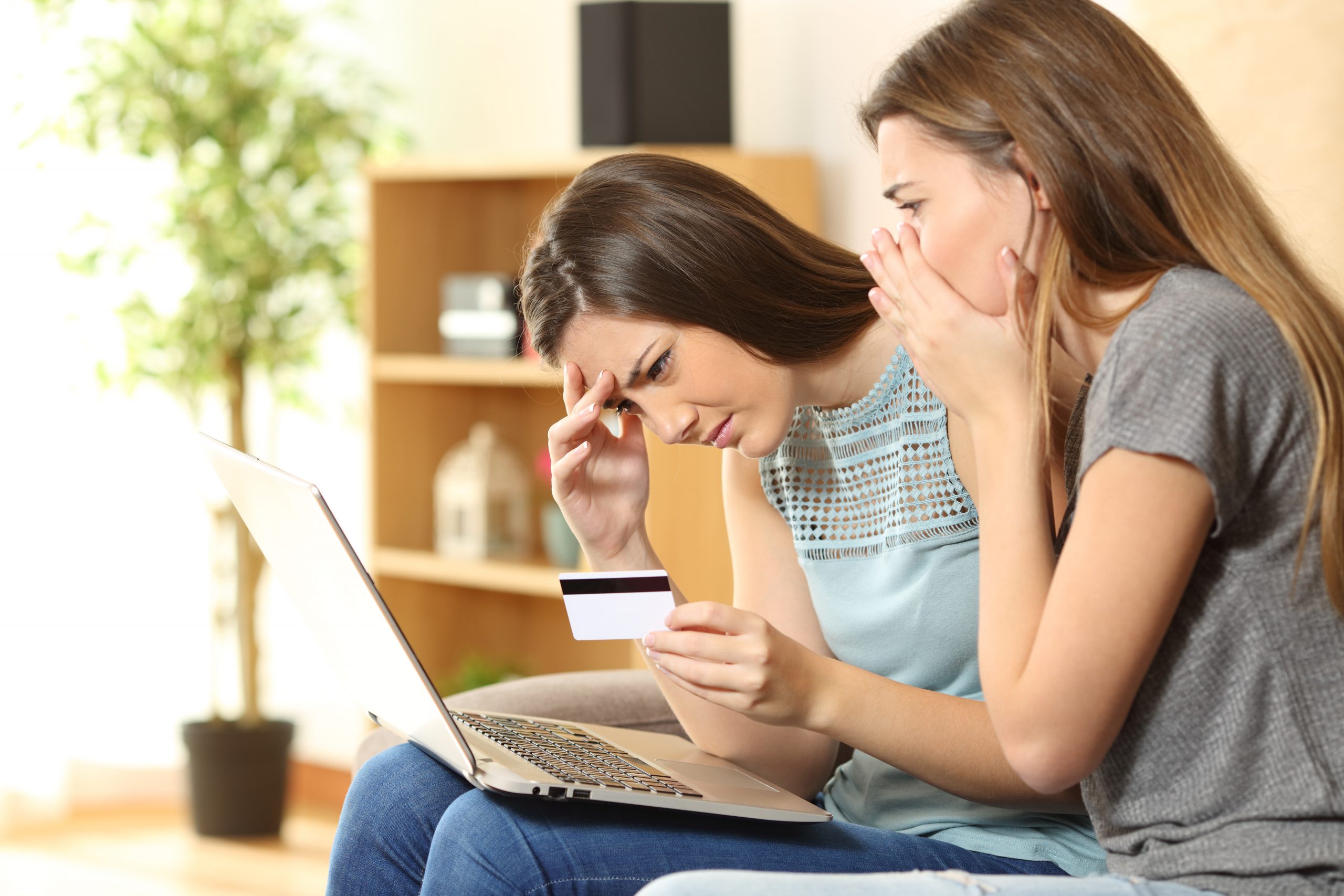 Two teenage girls with laptop and credit card in hand