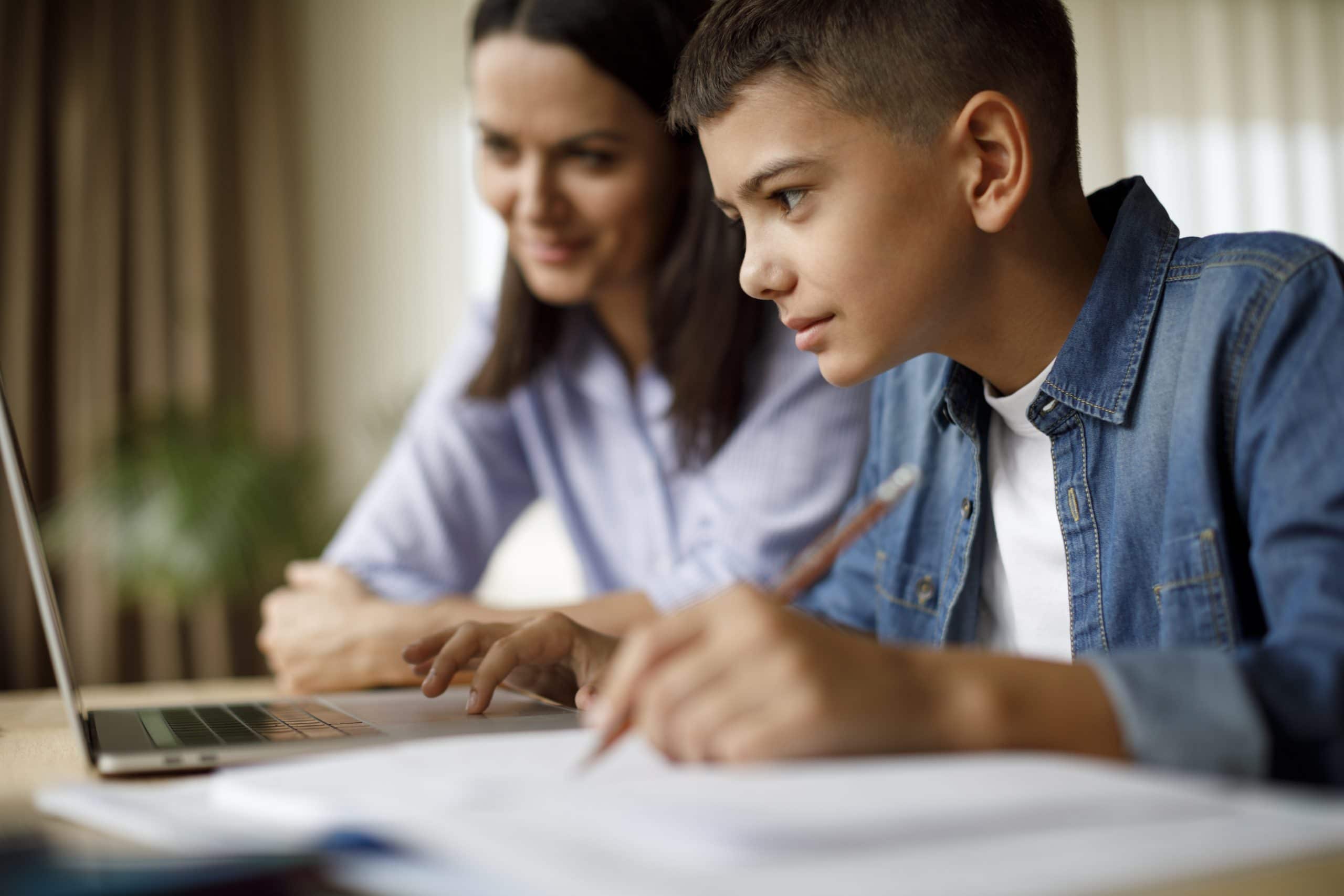 Mother helping teenager son with homework